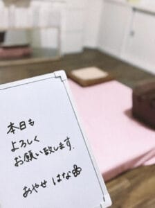 a hand holding a sign with writing on it