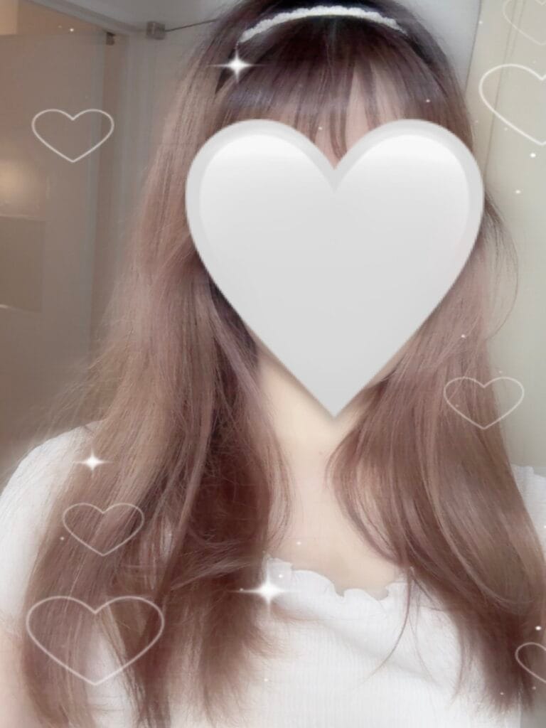 a woman with long hair and heart shaped object over her face